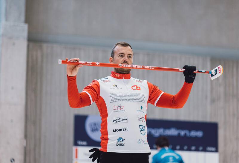 Curling Team Brunner Spieler hält einen Schläger in der Luft mit dem Securitas Direct Logo